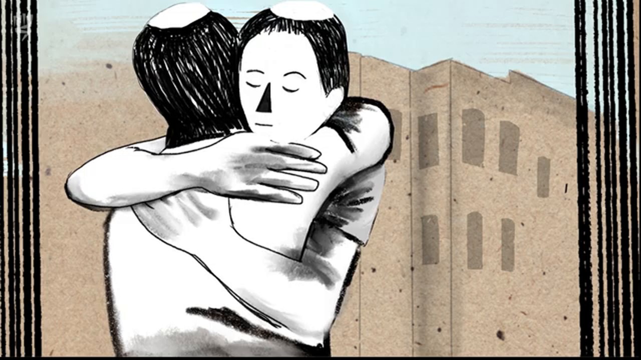 פריים מהסרט: שני גברים בכיפות מחבקים זה את זה חזק מול בניין