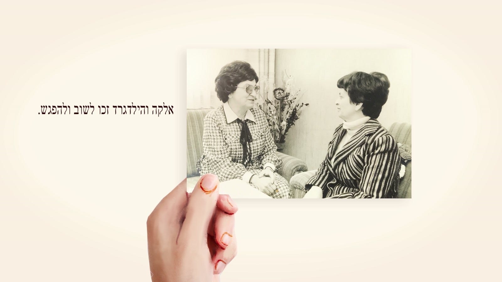 פריים מהסרט: יד מחזיקה את התצלום מהמפגש המחודש של אלקה והילדגרד